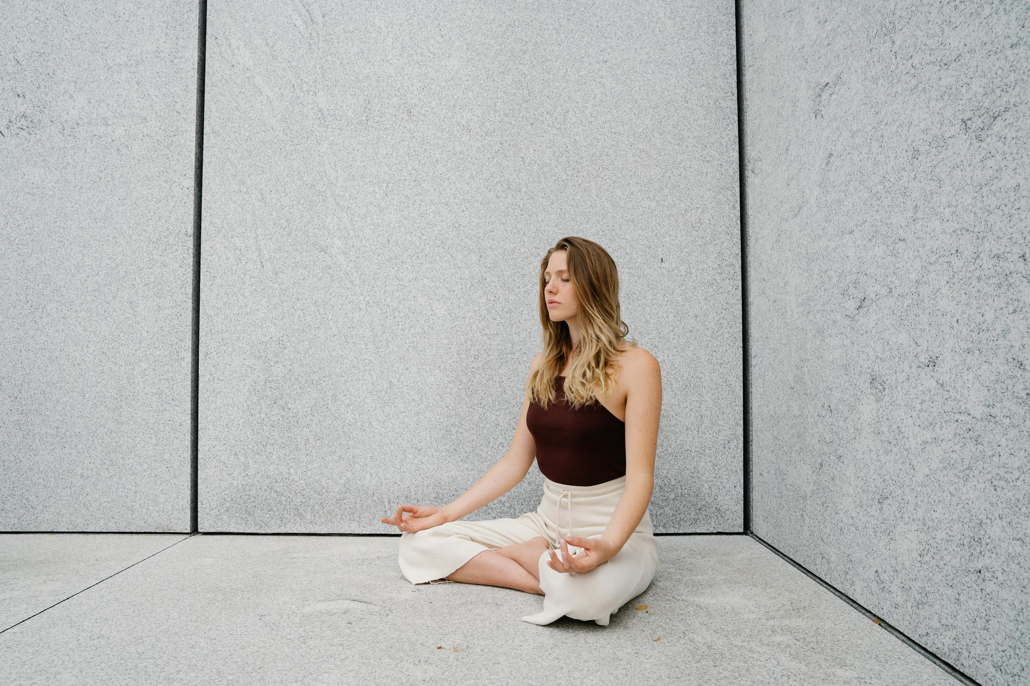 Young woman practicing yoga meditation indoors with calm expression and peaceful atmosphere.